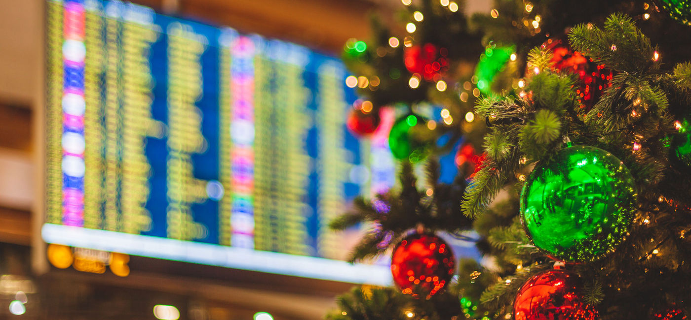 Image: PHOTO: Christmas tree in front of an airport departures board. (Photo via iStock/Getty Images Plus/Visionkick)