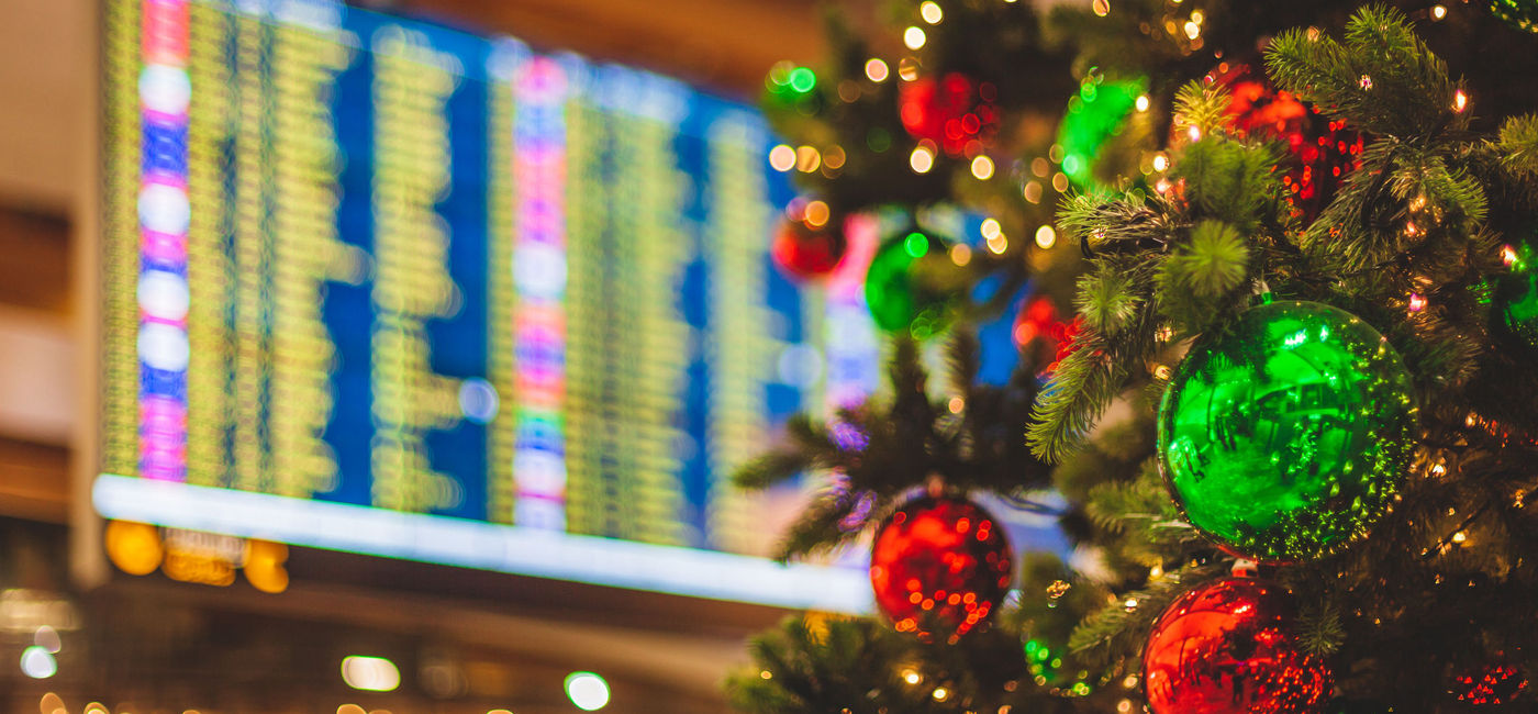 Image: PHOTO: Christmas tree in front of an airport departures board. (Photo via iStock/Getty Images Plus/Visionkick)