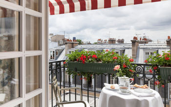 Balcony with red and white stripped awning, white tablecloths and fine china