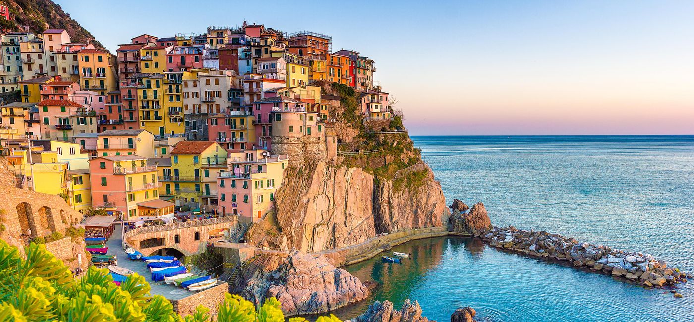 Image: PHOTO: Sunset in Manarola, Cinque Terre, Italy. (photo via ronnybas / iStock / Getty Images Plus)