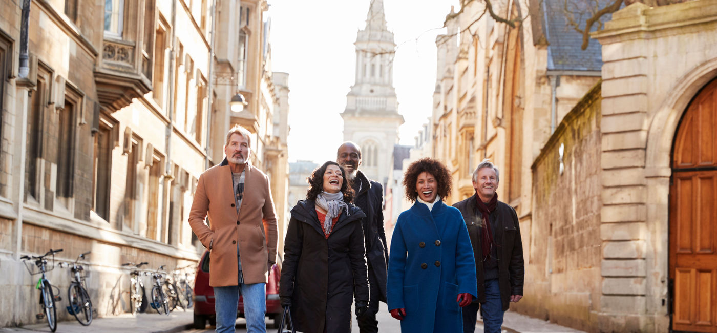 Image: A group tour walking through the city. (photo via monkeybusinessimages / Getty Images)