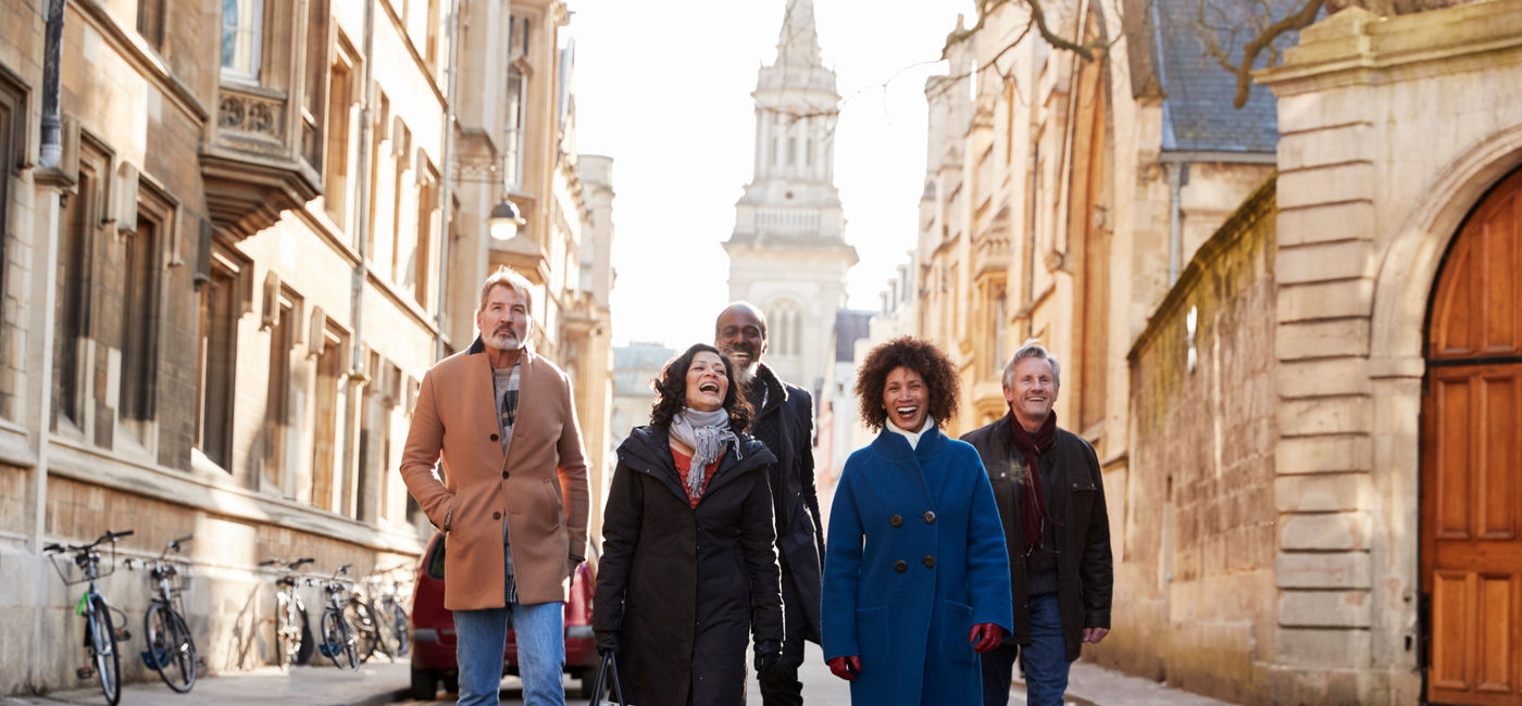 Image: Caption: A group tour walking through the city. (photo via monkeybusinessimages / Getty Images)