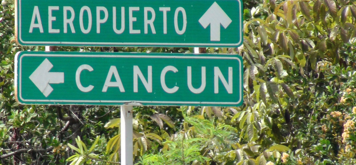 Image: Un signe pointant vers l'aéroport de Cancun. (photo via iStock / Getty Images Plus / LIVINUS)