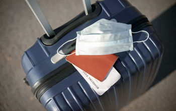 suitcase, passport and medical mask