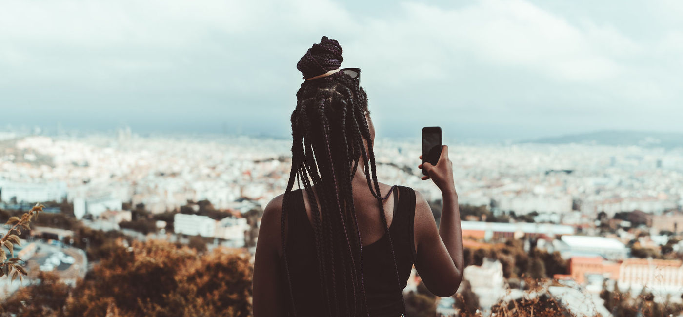 Image: Young black woman taking a photo of Barcelona. (photo via  iStock / Getty Images Plus /  skyNext)