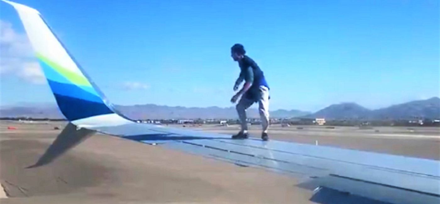 Image: PHOTO: Passenger video shows a man on the wing of a plane on Saturday. (Brooke Knight/Twitter) (Brooke Knight)