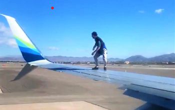 Man on wing of plane