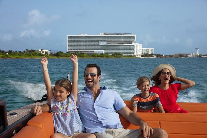 Family enjoying a boat ride from Dreams Vista Cancun Golf & Spa Resort