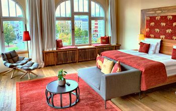 Hotel suite with red accents elephant pillows gray easy chair