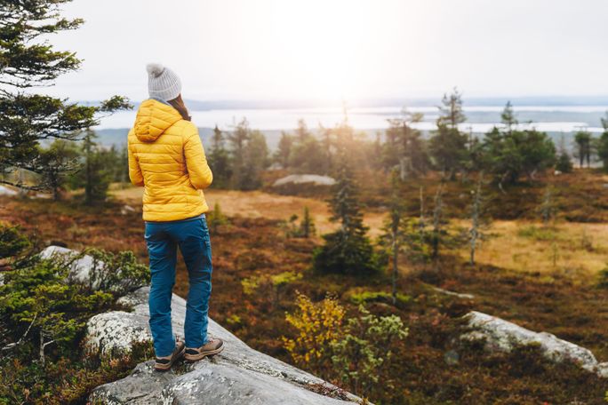Woman traveler in yellow puffer jacket Woman traveler in yellow puffer jacket