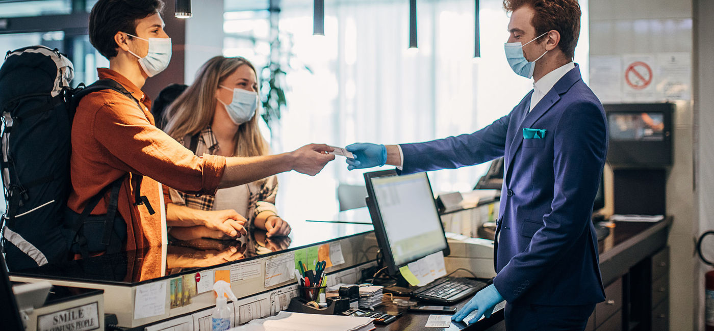 Image: Couple checking into a hotel. (photo via South_agency/E+)