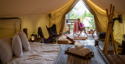 Woman sitting outside luxury tent on glamping trip in Glacier National Park