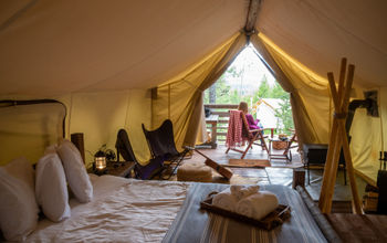 Woman sitting outside luxury tent on glamping trip in Glacier National Park