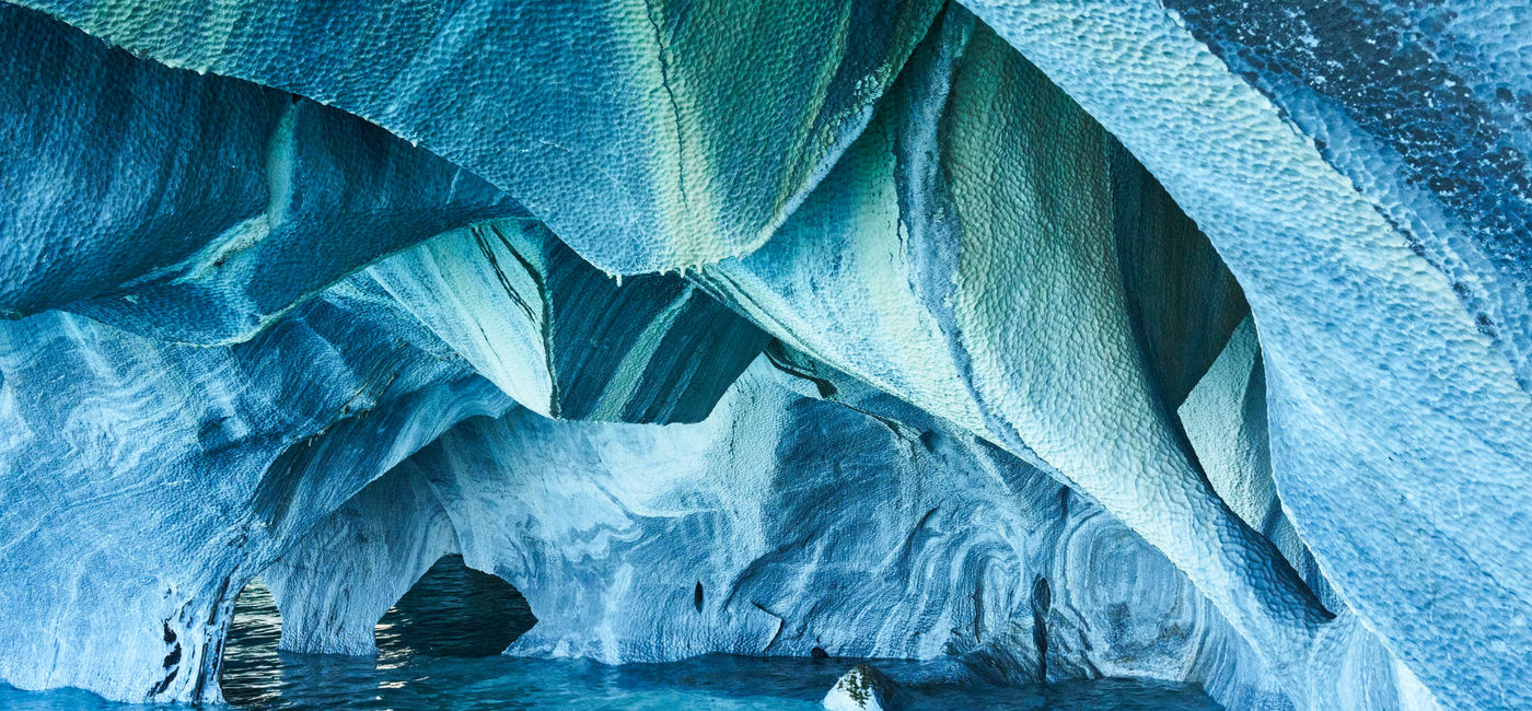 Image: Chile's Marble Caves are often a stunning blue color. (photo via iStock / Getty Images Plus /  Nektarstock)