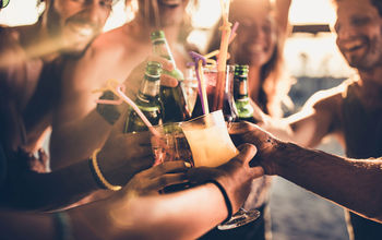 Friends toasting with alcohol at sunset