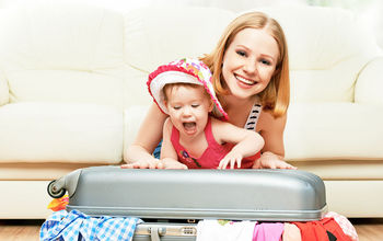A baby girl helps mom pack a suitcase