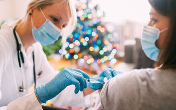 A woman getting vaccinated against COVID-19 prior to holiday travel.