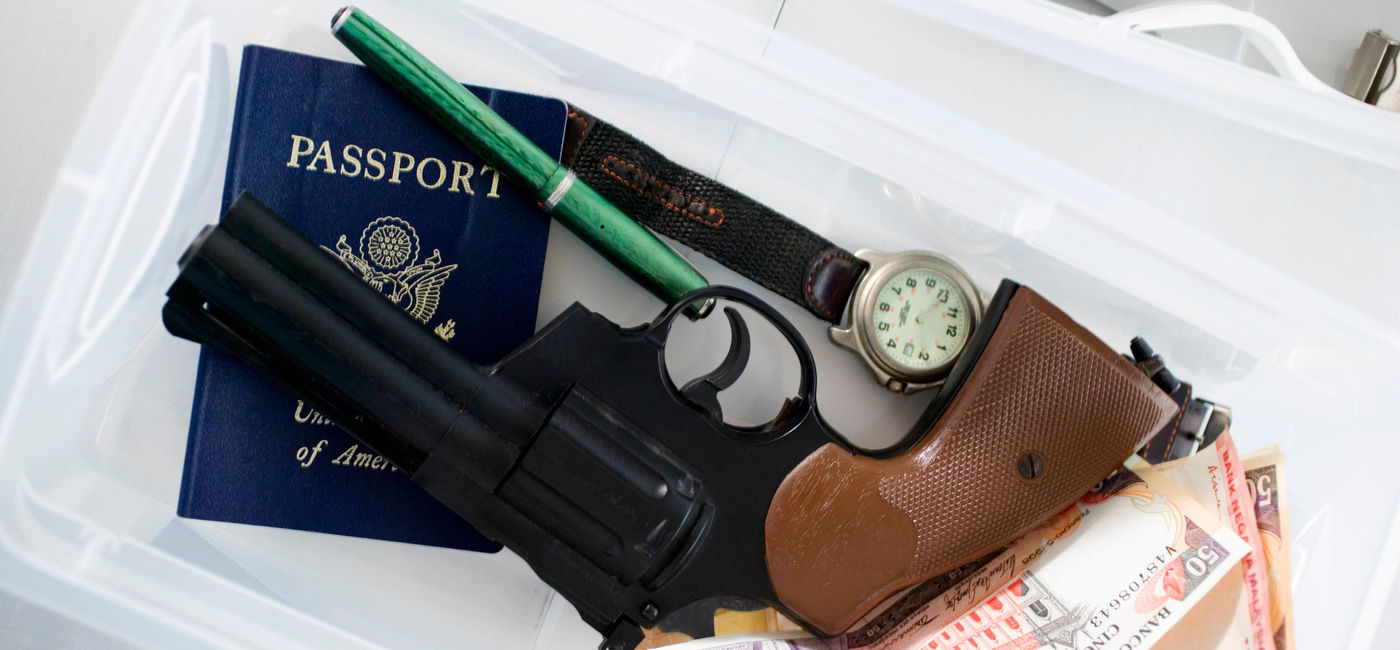 Image: Gun in airport screening tray. (photo via Creatas / Creatas / Getty Images Plus)