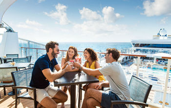 Friends enjoying cocktails at Sky High Bar aboard Norwegian Star