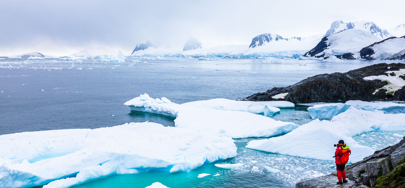 Image: Tourist taking photos in Antarctica. (photo via iStock / Getty Images Plus / NicoElNino)