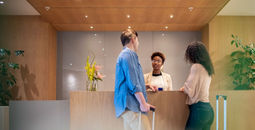 Couple talking to receptionist at hotel lobby