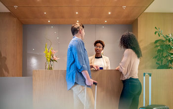 Couple talking to receptionist at hotel lobby