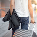 Man holding suit and luggage