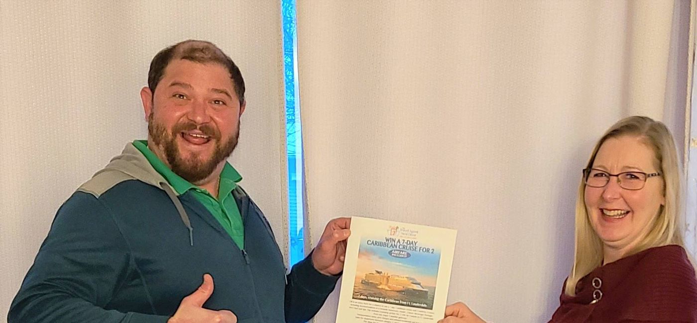 Image: Paul Vendetti receives his free cruise from TTAND agent Jennifer Jones. (The Travel Agent Next Door)