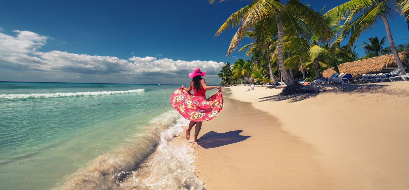 Image: PHOTO: Woman walking on the beach in the Dominican Republic. (photo via valio84sl/iStock/Getty Images Plus)