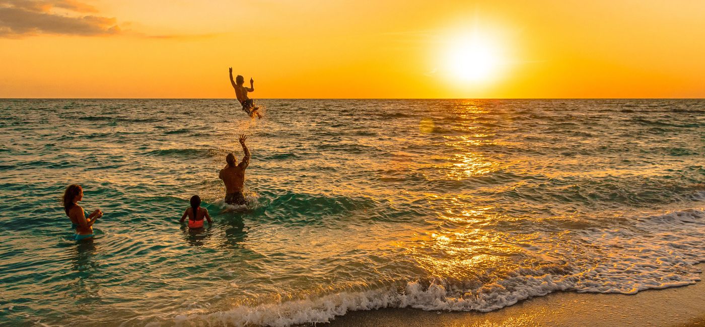 Image: A family playing in the ocean. (photo via The Beaches of Fort Myers & Sanibel) (Lee VCB)