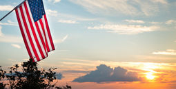 Bright american flag flying above beautiful sunset over Mississippi river