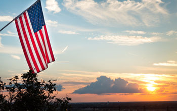 Bright american flag flying above beautiful sunset over Mississippi river