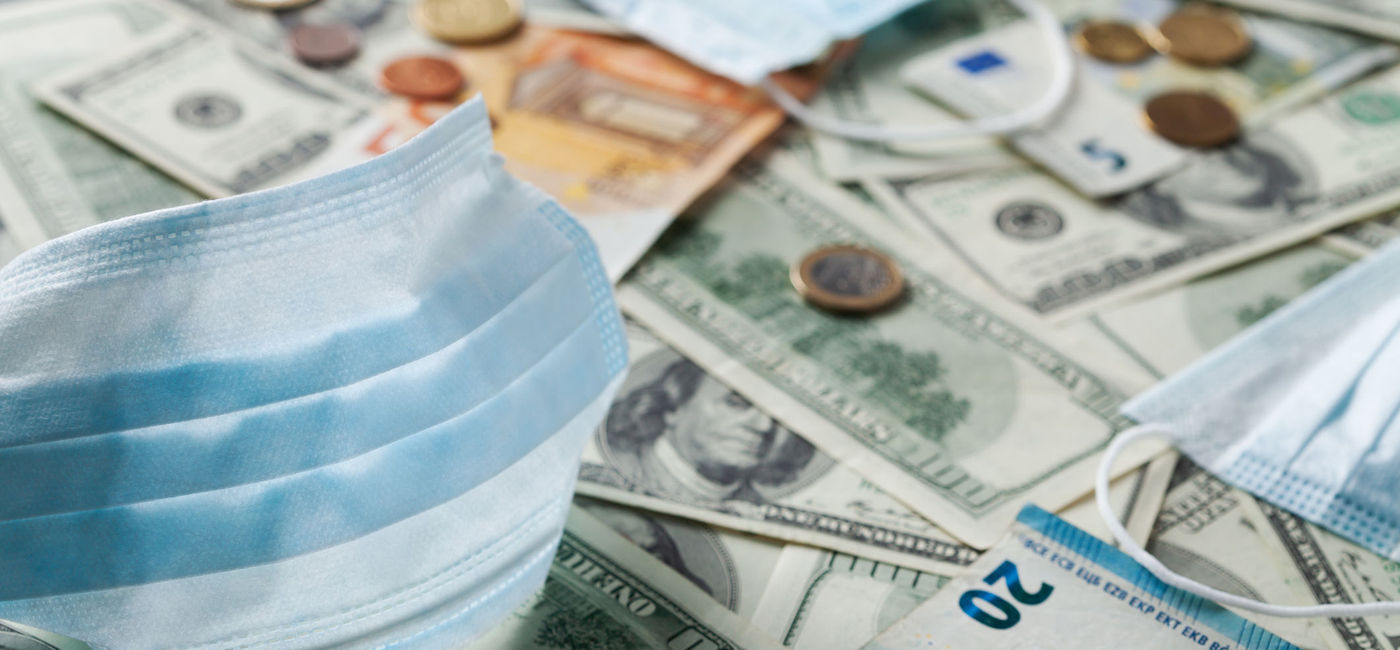 Image: Medical face mask and money from around the world. (Photo via iStock/Getty Images Plus/Julia_Sudnitskaya)
