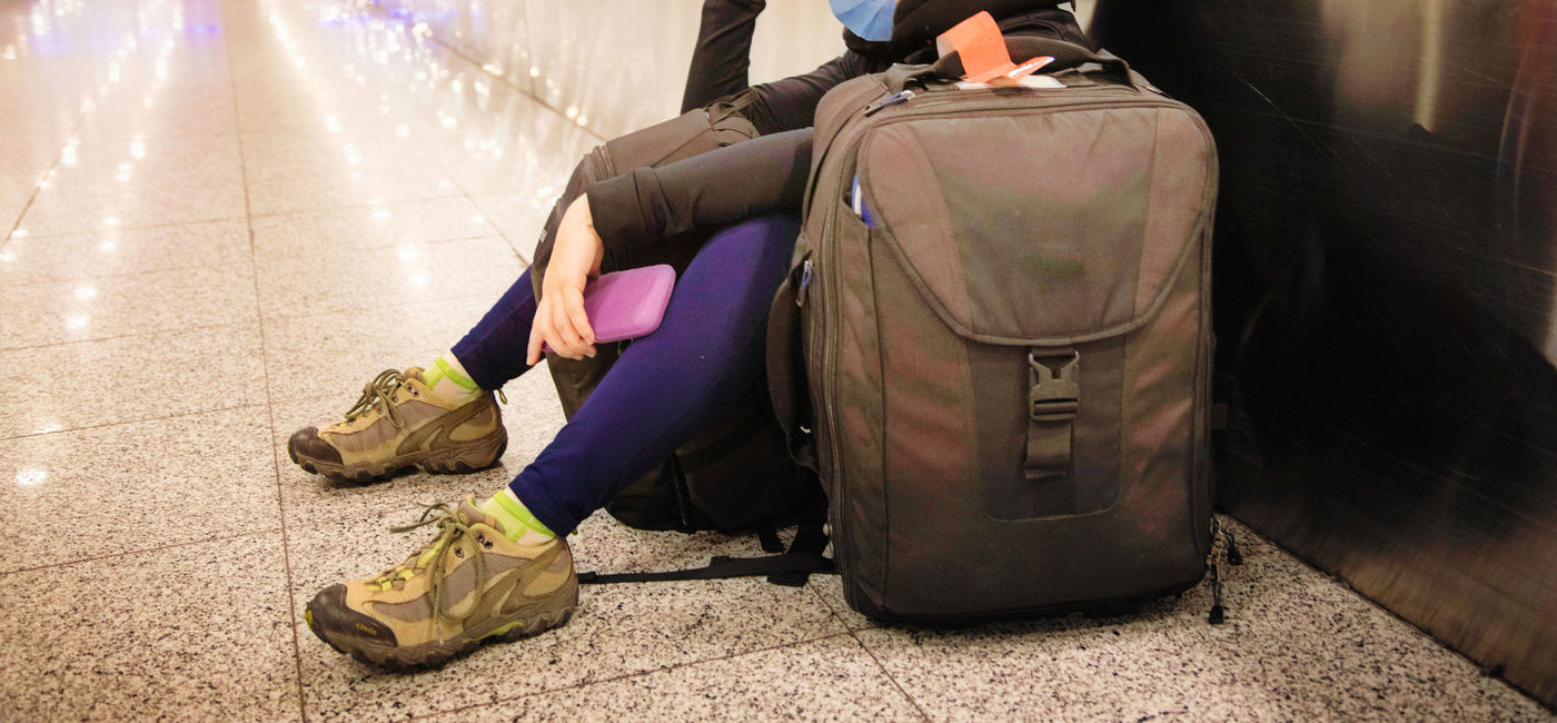 Image: Frustrated traveler waiting for her flight. (photo via iStock/Getty Images E+/NicolasMcComber)
