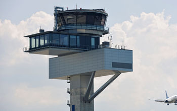 Air traffic control tower and jet aircraft approaching to land