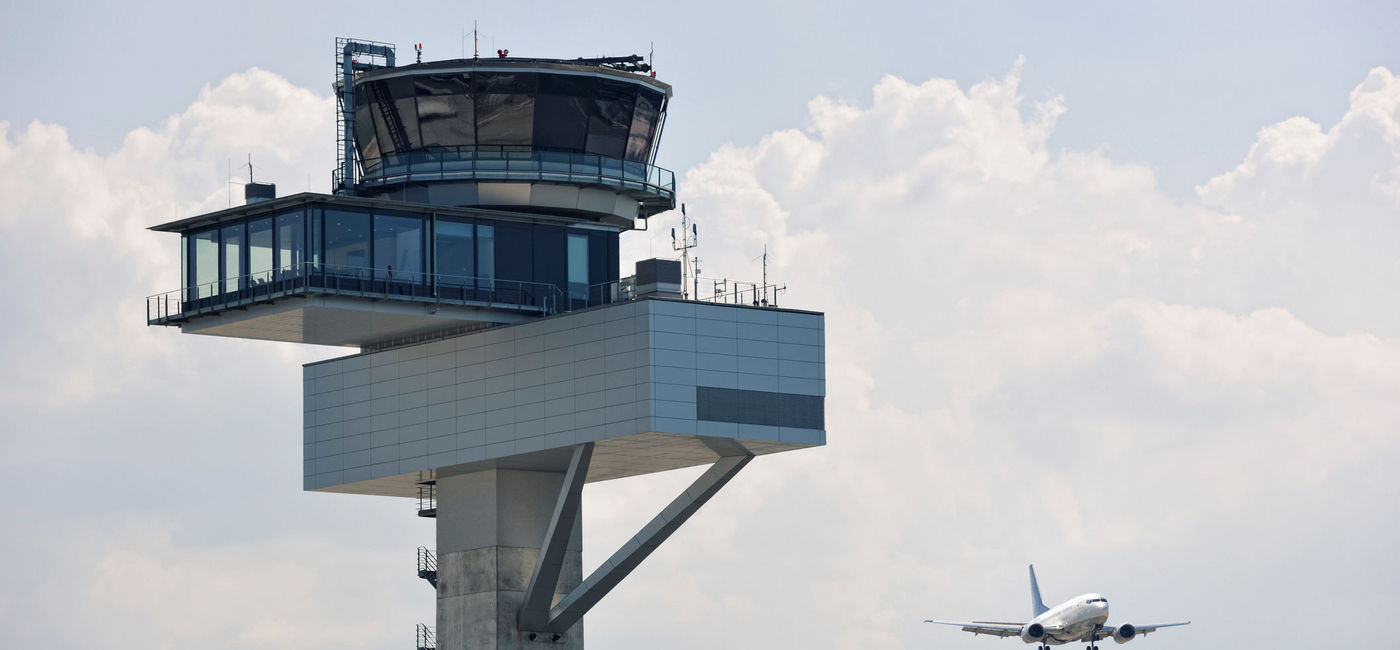 Image: Air traffic control tower and jet aircraft approaching to land. (Photo Credit: southerlycourse/E+)