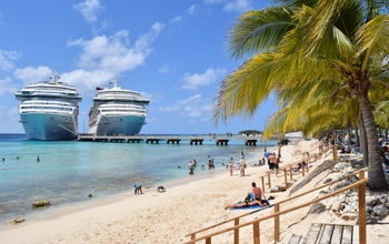 Carnival Cruise ships docked side-by-side in the Caribbean.