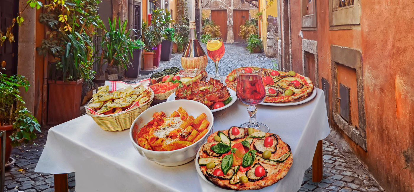 Image: Italy pasta, pizza and other food items at a restaurant in Rome. (photo viaiStock / Getty Images Plus / maroznc)