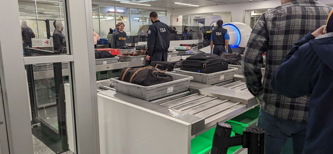 Image: Travelers place items in bins at TSA security line (photo by Eric Bowman)