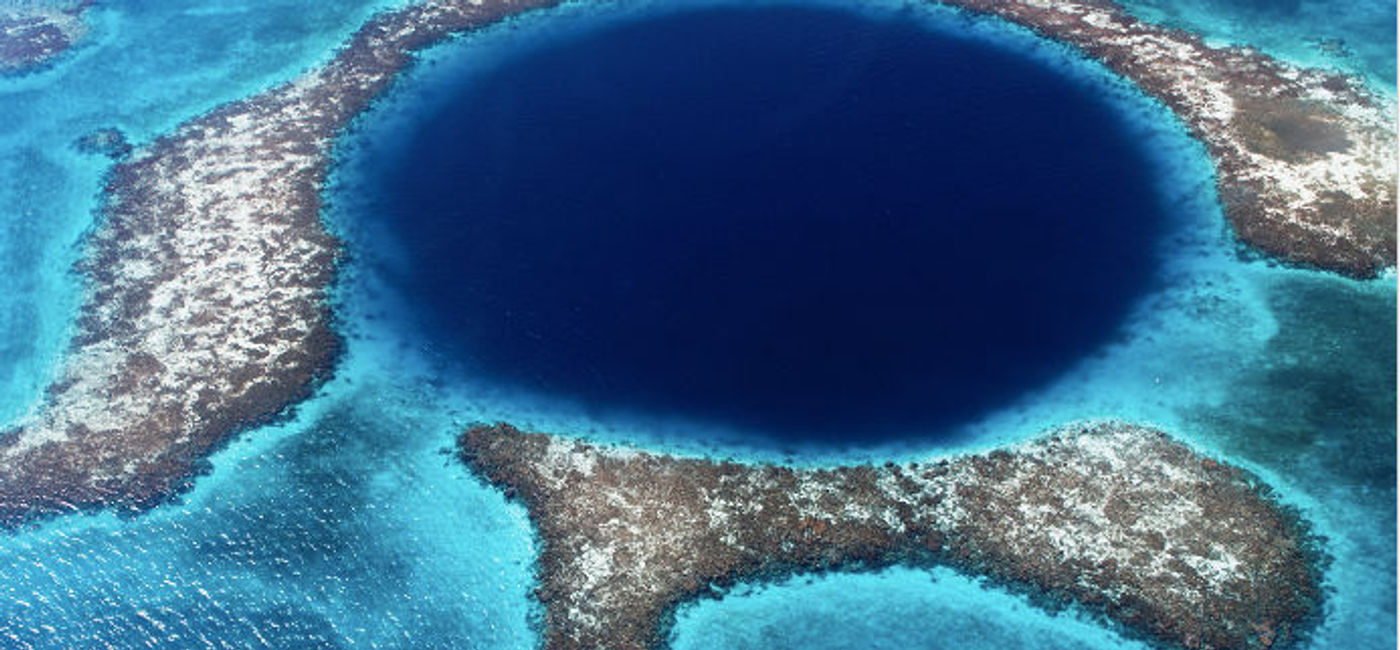Image: The magnificent Blue Hole is one of the many natural wonders that Belize offers its visitors. (Lomingen / iStock / Getty Images Plus).