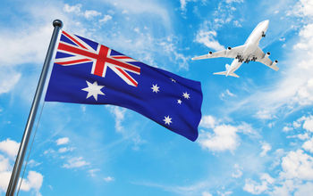 The Australian national flag with a plane flying overhead.