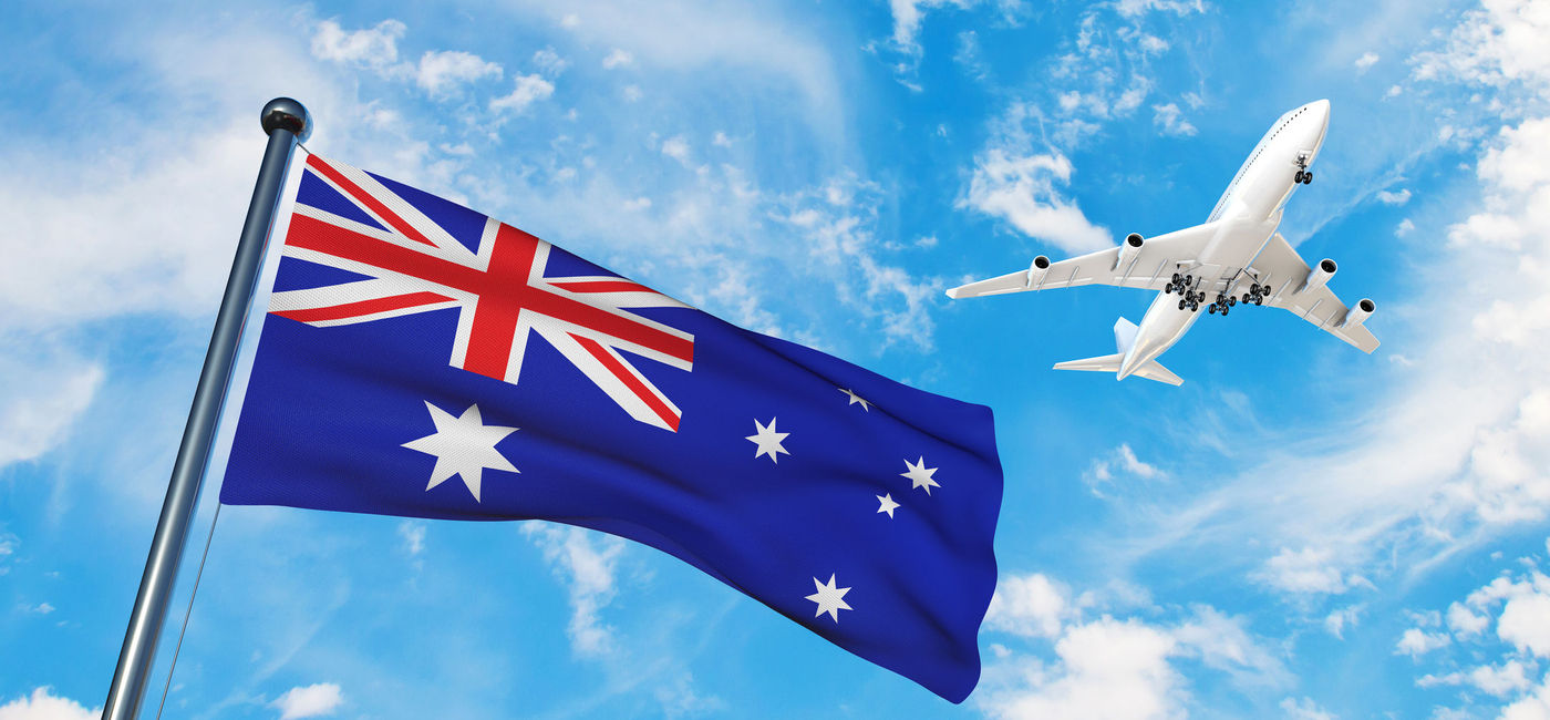 Image: The Australian national flag with a plane flying overhead. (photo via iStock/Getty Images Plus/fatido)
