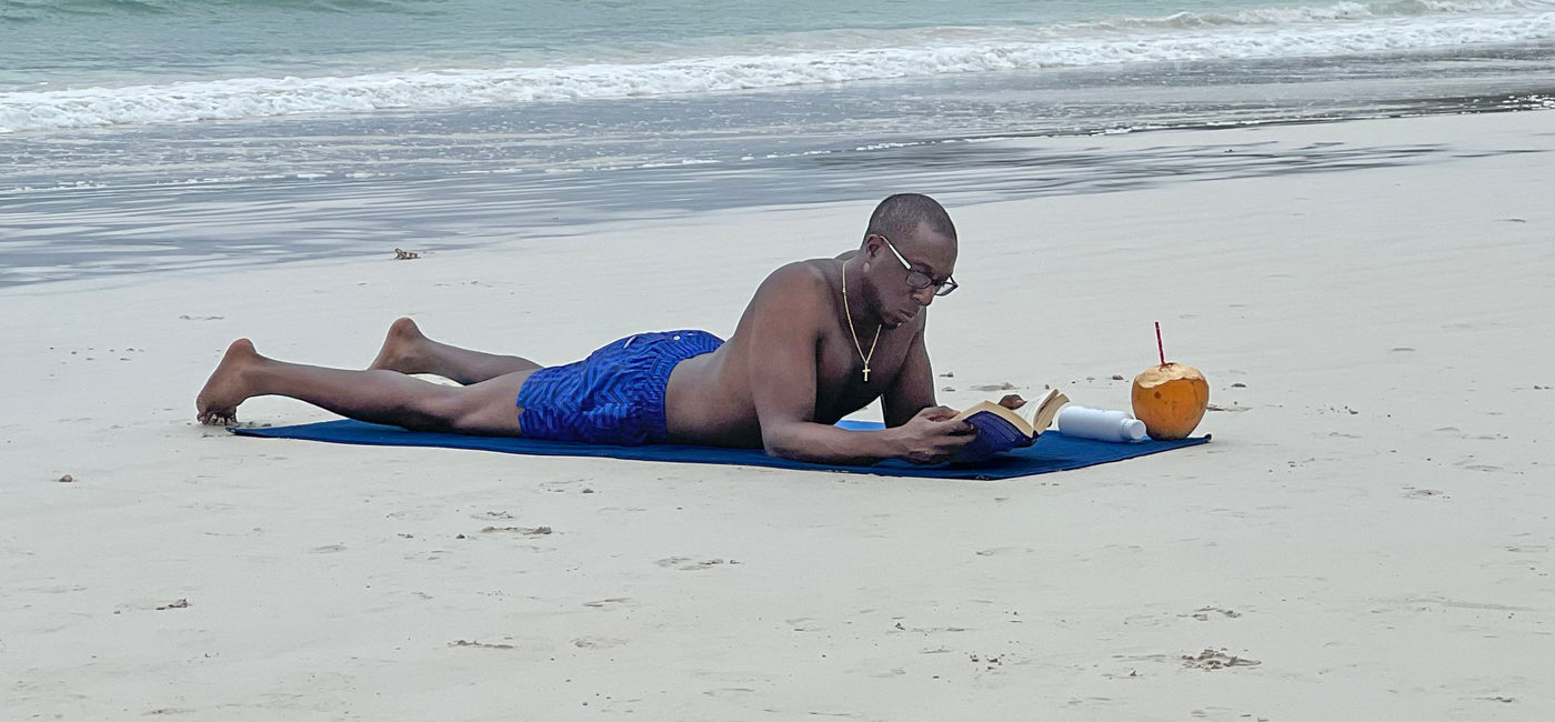 Image: The author's husband lounges on Cote D’Or beach in Praslin. (Photo Credit: Paul J. Heney)