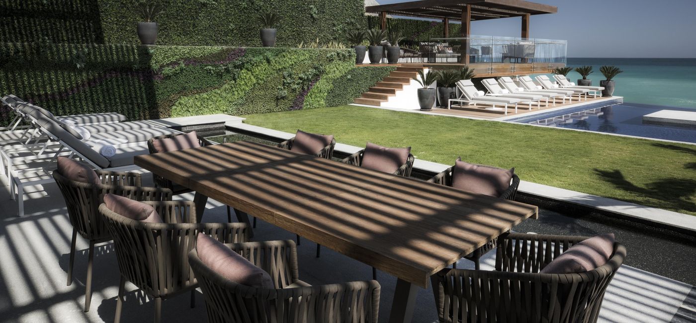 Image: View of the outdoor space of the Royale Residence. Includes a sun deck, infinity pool, dining table, and a gorgeous ocean view. (photo courtesy Palace Resorts)