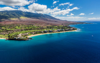 Ocean coastline with beach and mountains in background