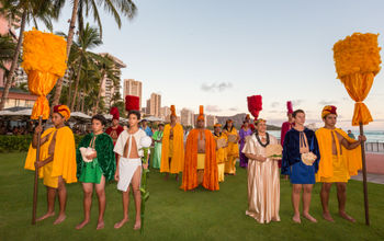 Aloha Festival court on Waikiki beach with traditional Hawaiian garb and kahili