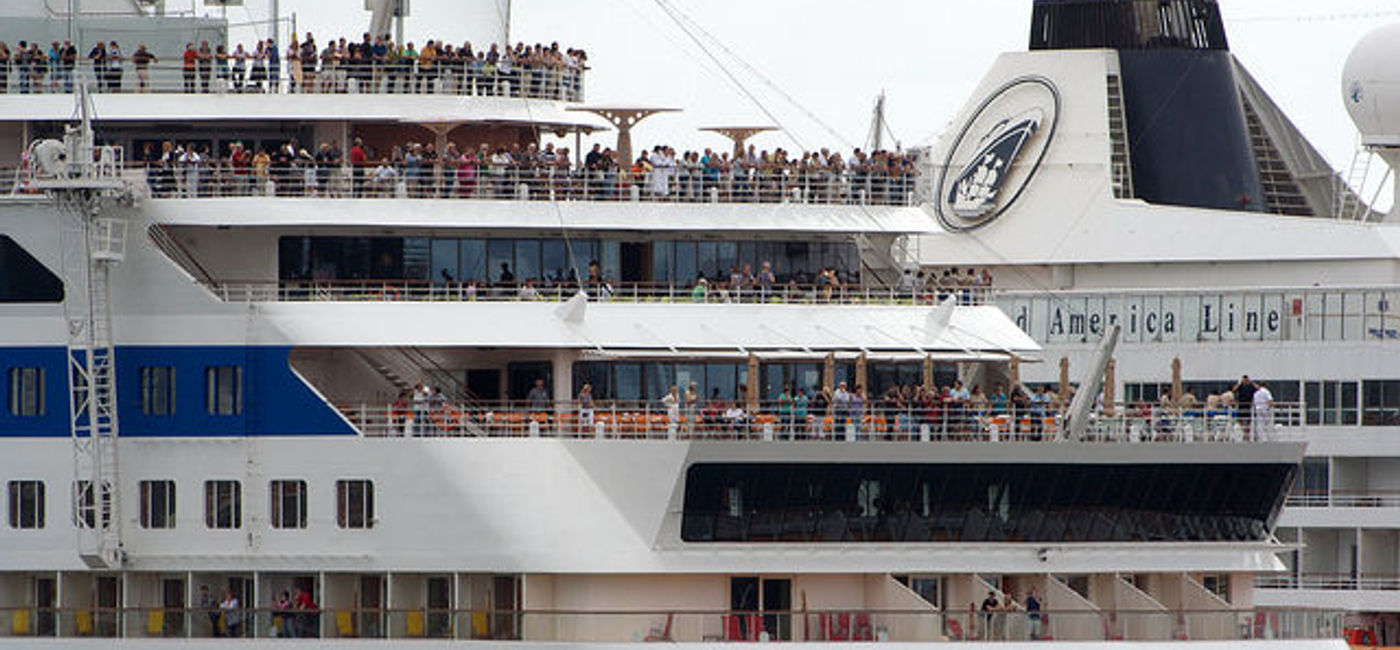 Image: PHOTO: Passengers mass on the rear deck of a cruise ship as it leaves the harbor. (photo via Flickr/Alexander Baxevanis)