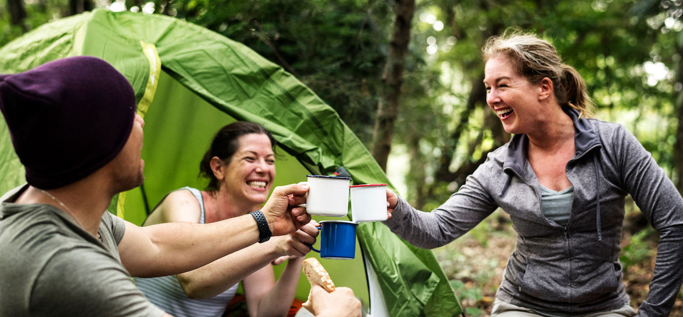 Image: A group camping in the woods. (Photo via Getty Images / Rawpixel)