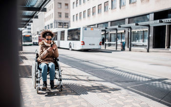 Woman in a wheelchair waiting on the bus