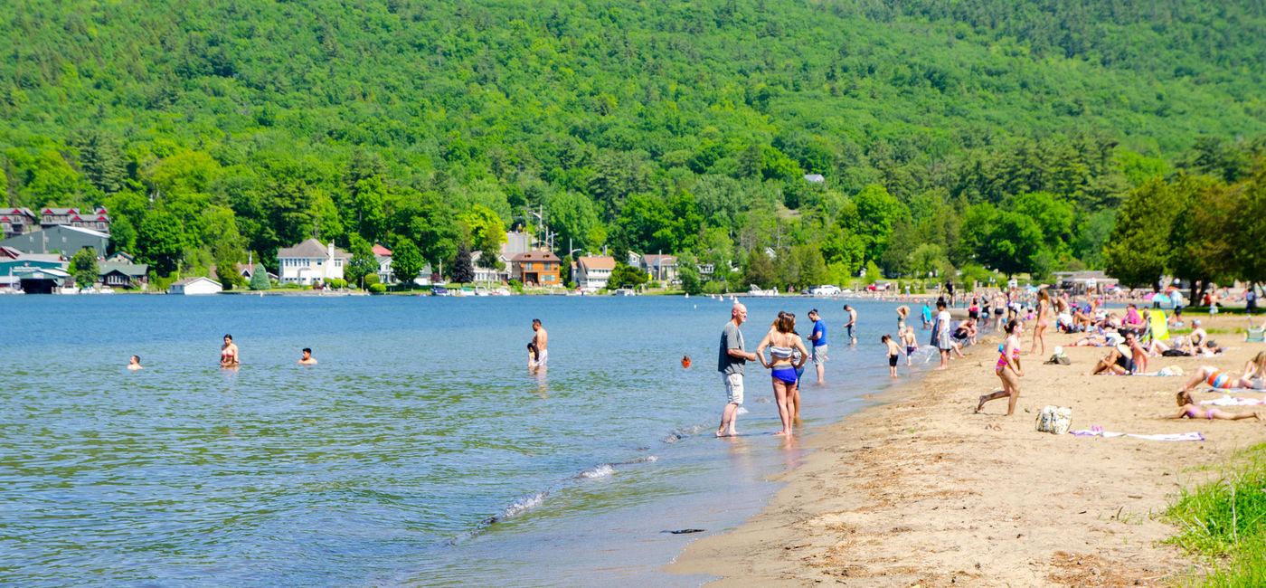 Image: Crowd of swimmers on the beach in Lake George, New York. (photo via Marc Dufresne/iStock Unreleased)